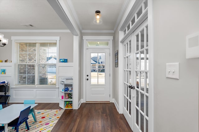 doorway featuring crown molding, dark hardwood / wood-style flooring, a chandelier, and french doors