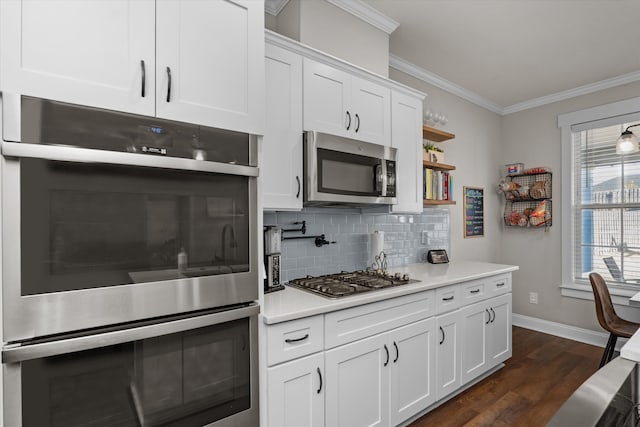 kitchen with crown molding, white cabinetry, stainless steel appliances, dark hardwood / wood-style floors, and tasteful backsplash