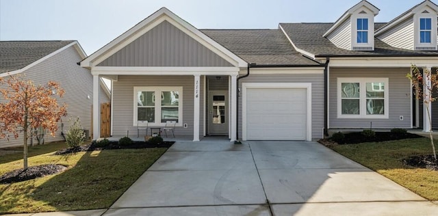 view of front facade featuring covered porch, a front lawn, and a garage