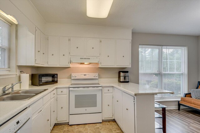 kitchen featuring kitchen peninsula, white cabinetry, white appliances, and sink