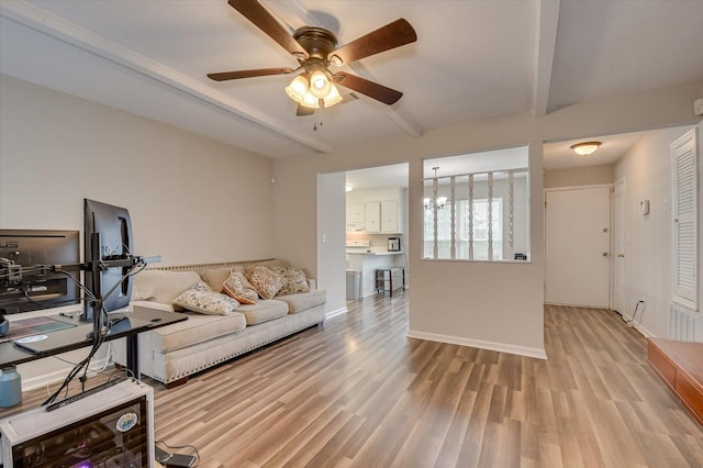 living room with ceiling fan, light hardwood / wood-style flooring, and beamed ceiling