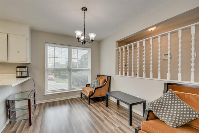 sitting room featuring a chandelier and light wood-type flooring