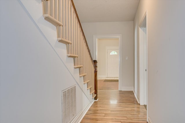 1107 Heard Ave, Augusta, GA 30904 - corridor featuring light wood finished floors, stairway, and a textured ceiling