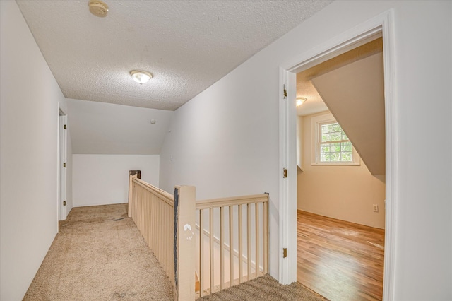 1107 Heard Ave, Augusta, GA 30904 - corridor featuring an upstairs landing, a textured ceiling, vaulted ceiling, and light colored carpet