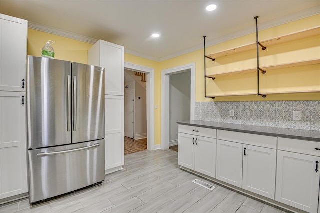 1107 Heard Ave, Augusta, GA 30904 - kitchen featuring freestanding refrigerator, decorative backsplash, dark countertops, ornamental molding, and white cabinetry