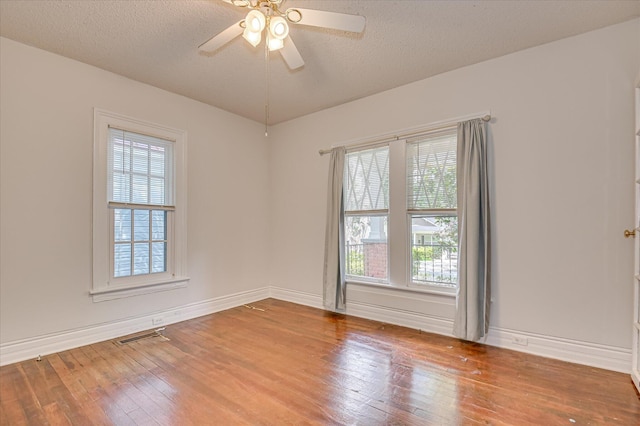 1107 Heard Ave, Augusta, GA 30904 - unfurnished room featuring hardwood / wood-style floors, healthy amount of natural light, a ceiling fan, and a textured ceiling