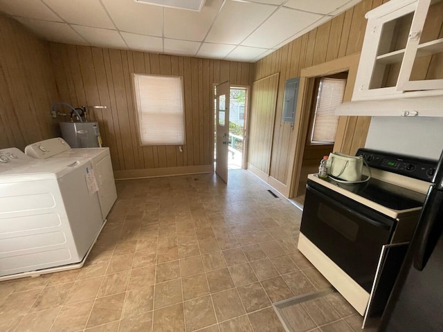 laundry area with washer and clothes dryer, electric water heater, and wooden walls