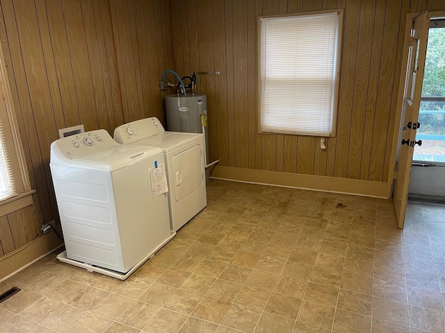 washroom with wood walls and washing machine and dryer