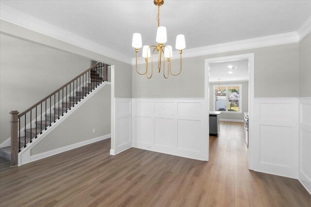 5511 Sweetwater Dr, Grovetown, GA 30813 - unfurnished dining area featuring stairs, a chandelier, ornamental molding, wood finished floors, and wainscoting