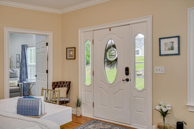 foyer entrance featuring wood-type flooring and ornamental molding