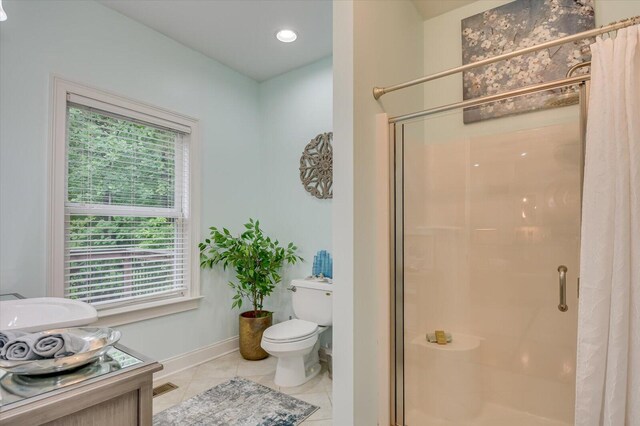 bathroom featuring a wealth of natural light, vanity, toilet, and an enclosed shower