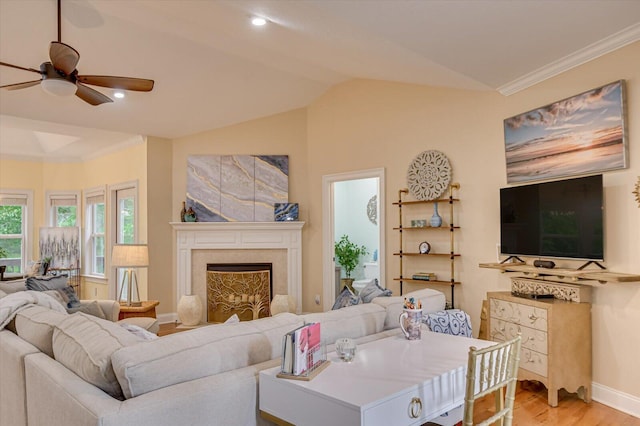 living room with ceiling fan, light hardwood / wood-style flooring, a premium fireplace, and vaulted ceiling