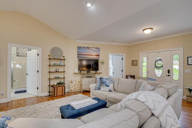 living room with light hardwood / wood-style floors and vaulted ceiling