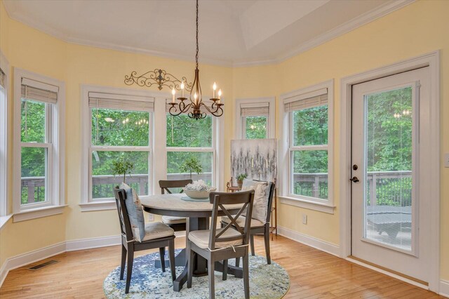 dining area with an inviting chandelier, plenty of natural light, and ornamental molding