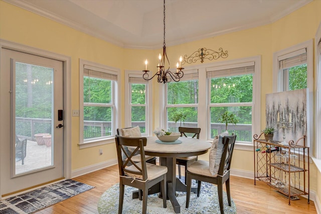 dining room featuring crown molding, a notable chandelier, and light wood-type flooring