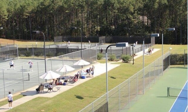 view of community with tennis court and a yard