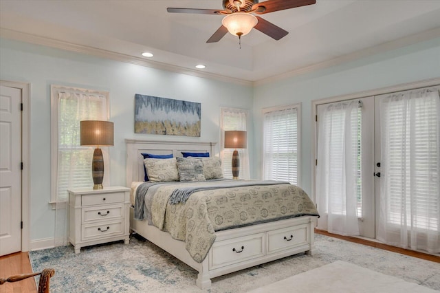 bedroom featuring access to exterior, french doors, a raised ceiling, ceiling fan, and light hardwood / wood-style flooring