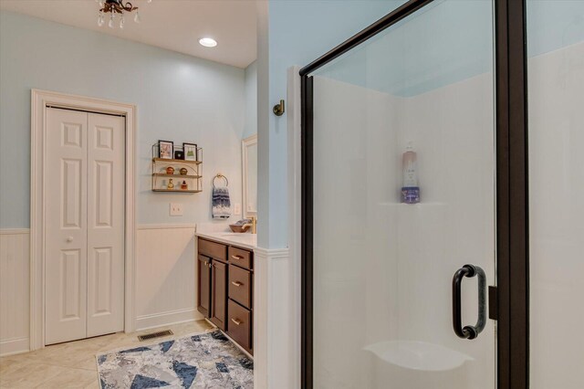 bathroom featuring tile patterned floors, vanity, and a shower with shower door