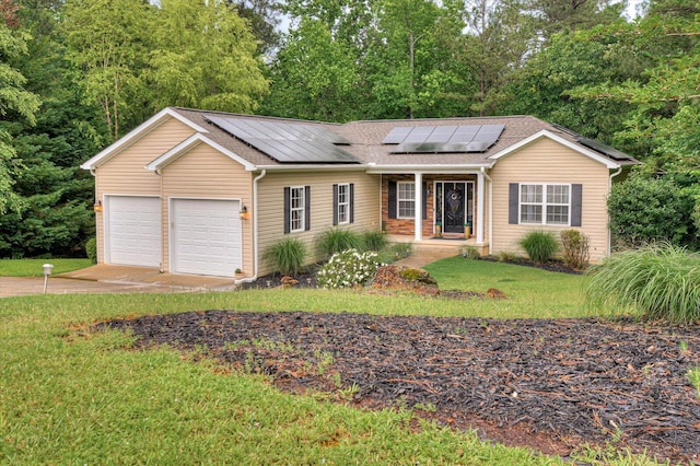 ranch-style house featuring a front yard, solar panels, a garage, and covered porch