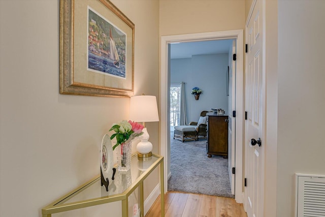 hallway featuring light wood-style floors and visible vents