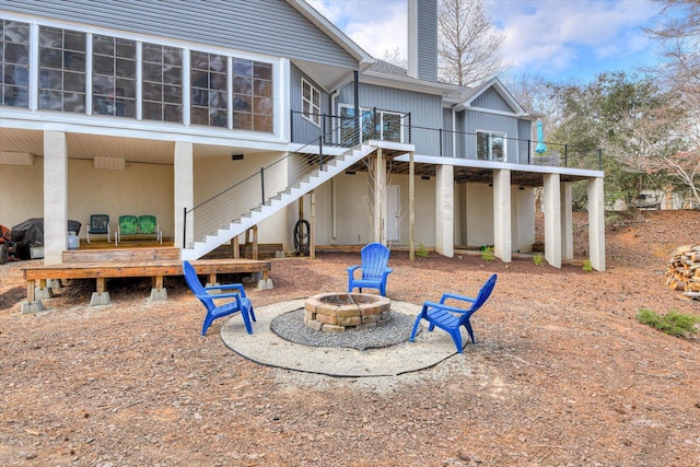 rear view of house featuring a chimney, stairway, a patio area, a fire pit, and a wooden deck