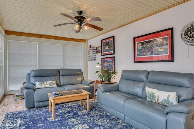 living room with ceiling fan, ornamental molding, and wood finished floors