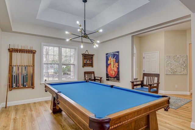 game room with arched walkways, a raised ceiling, light wood-style flooring, billiards, and baseboards