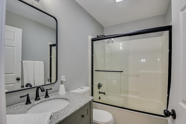 bathroom featuring bath / shower combo with glass door, vanity, and toilet