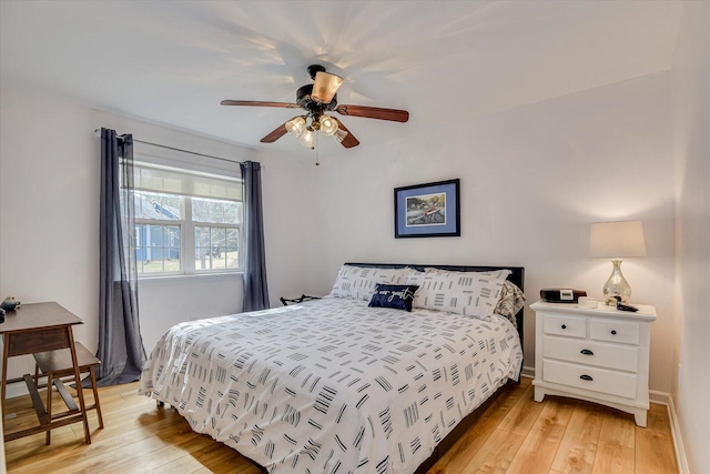 bedroom with ceiling fan, light wood finished floors, and baseboards