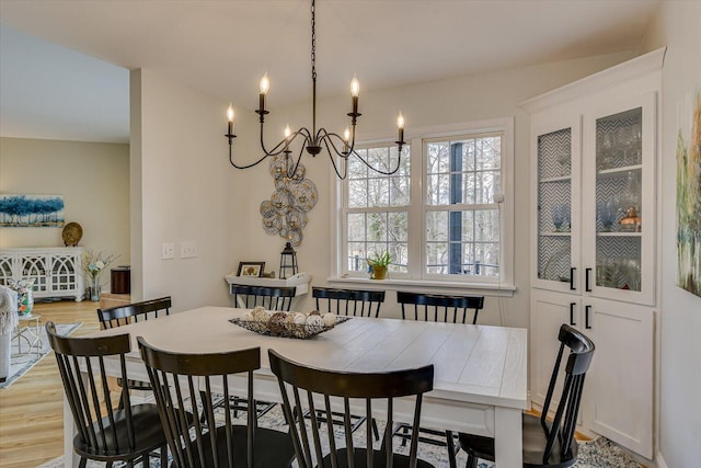 dining area featuring light wood finished floors and a chandelier