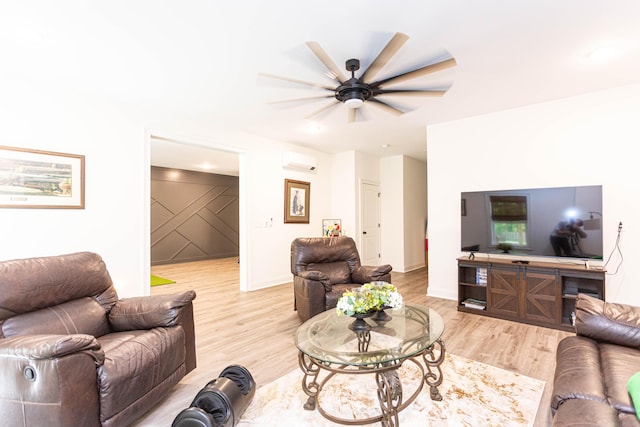 living area featuring light wood finished floors, ceiling fan, a wall mounted AC, and baseboards