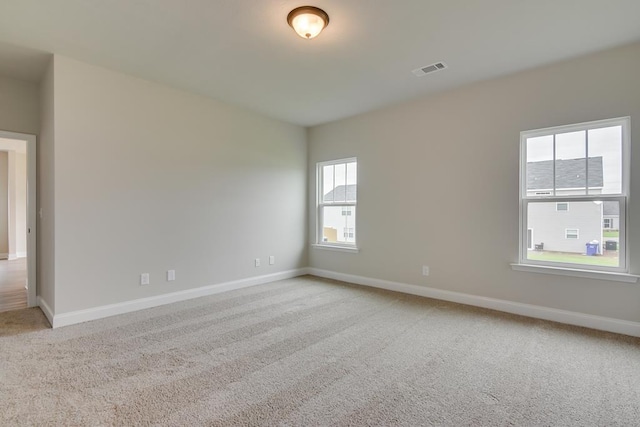 spare room featuring light colored carpet