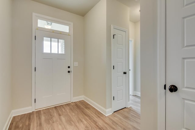 foyer entrance featuring baseboards and light wood-style floors