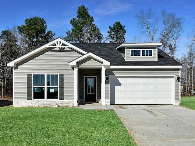 view of front of property featuring a garage, a front yard, concrete driveway, and stone siding