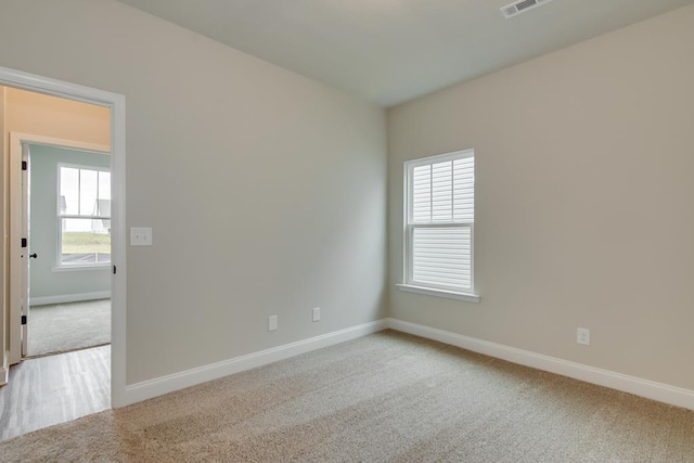 carpeted spare room featuring a healthy amount of sunlight