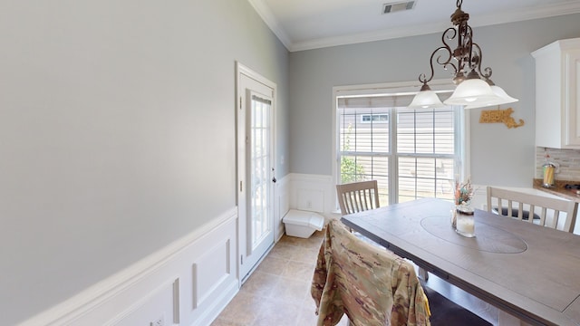 2054 Dundee Way, Grovetown, GA 30813 - dining space with light tile patterned flooring, a wainscoted wall, crown molding, and a decorative wall