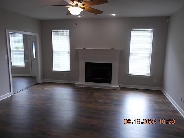 967 Windmill Pkwy, Evans, GA 30809 - unfurnished living room featuring wood finished floors, a ceiling fan, and a fireplace with raised hearth