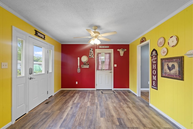 entryway featuring plenty of natural light, ornamental molding, wood finished floors, a textured ceiling, and a ceiling fan