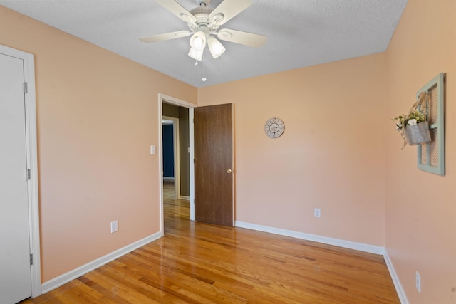 unfurnished bedroom with light wood-type flooring, baseboards, and a ceiling fan