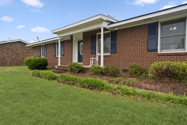 single story home featuring a front lawn, covered porch, and brick siding