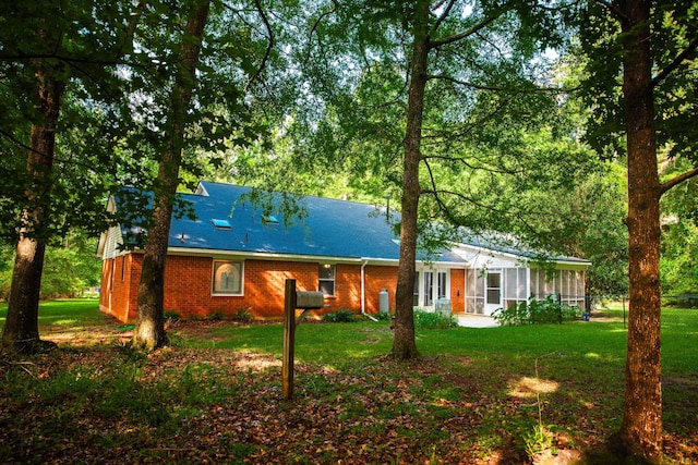 back of house with a sunroom and a yard