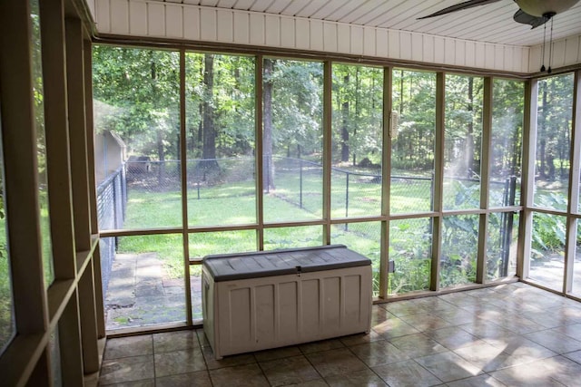 unfurnished sunroom featuring ceiling fan and plenty of natural light