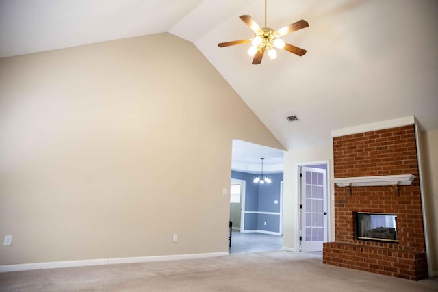 unfurnished living room with carpet, ceiling fan with notable chandelier, high vaulted ceiling, and a brick fireplace