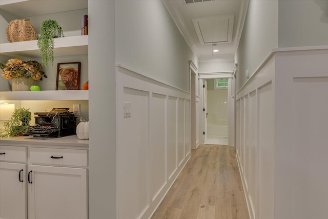 hall with light hardwood / wood-style flooring and crown molding