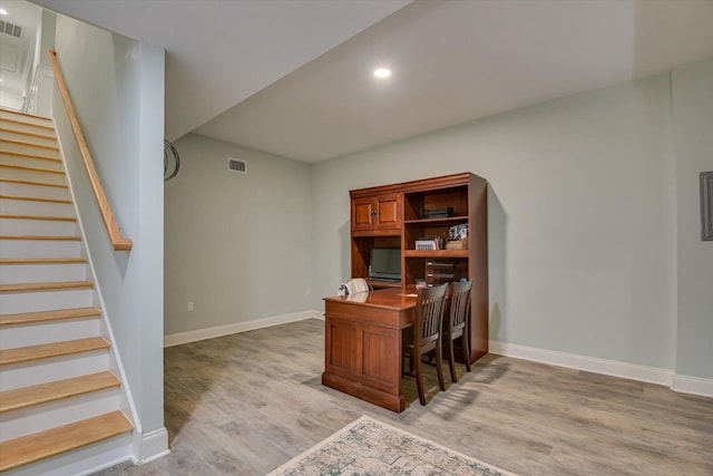 home office with light hardwood / wood-style flooring