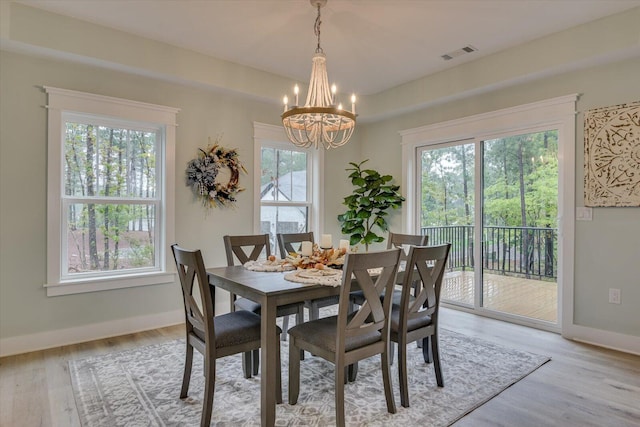 dining space featuring light hardwood / wood-style floors and a notable chandelier