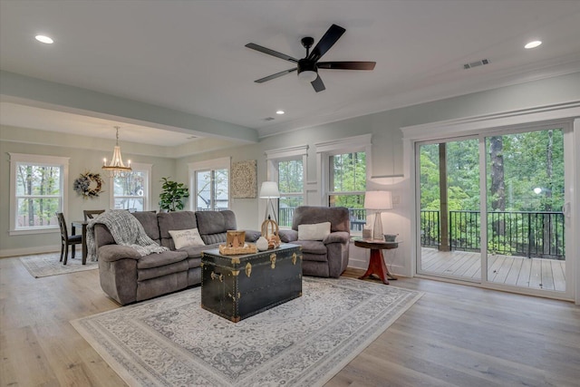 living room with light hardwood / wood-style floors and ceiling fan with notable chandelier