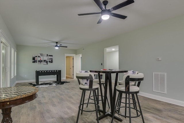 dining area with ceiling fan and wood-type flooring