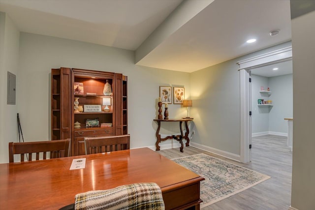 office featuring electric panel and light hardwood / wood-style flooring