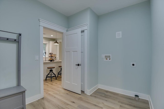 laundry room with hookup for a washing machine, light hardwood / wood-style flooring, and hookup for an electric dryer